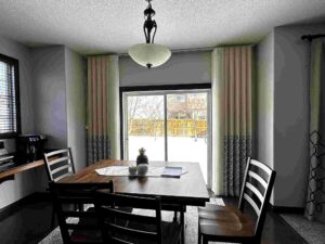 Vertical Sheers with Decorative Panels in front of a Dining Table in Calgary